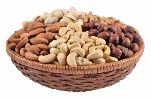 Assorted nuts in a wicker bowl on a white background Stock Photos