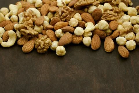 Assorted nuts on wooden surface. mix of nuts on brown table. Stock Photos