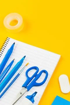 Assorted office and school white and blue stationery on yellow Stock Photos