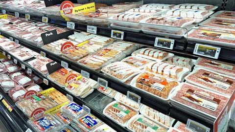 Assorted packaged meat products displayed on grocery store shelves. Foto stock