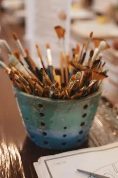 Assorted Paintbrushes in Colorful Holder on Table Stock Photos