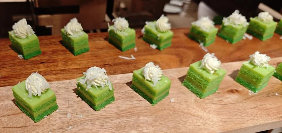 Assorted Pandan Layer Cakes with Whipped Cream on Buffet Dessert Display Stock-Fotos