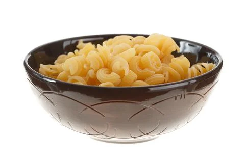 Assorted pasta in black round clay bowl isolated on white background Stock Photos