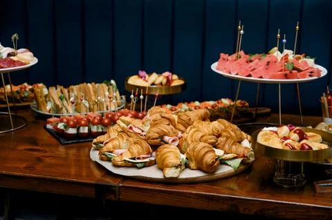 Assorted pastries and snacks displayed on wooden table at event Stock Photos