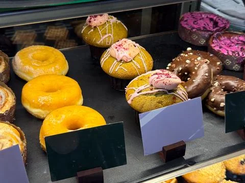 Assorted pastries and waffles displayed inside bakery showcase. Food selectio 스톡 사진