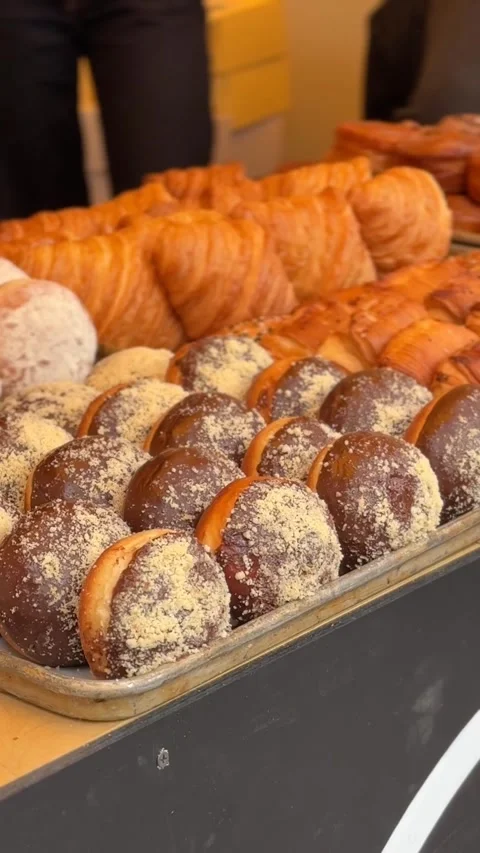 Assorted pastries with chocolate and sugar coating displayed on a bakery tr.. Stock Footage 336208395