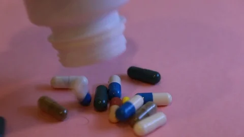 Assorted pharmaceutical medicine pills, tablets and capsules and bottle on pi Stock Footage 113418572