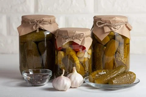 Assorted pickled vegetables in jars with spices and fresh garlic Stock Photos