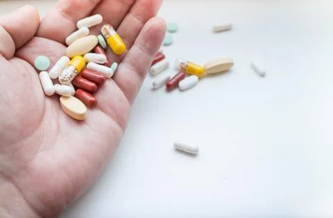 Assorted pills on hand Stock Photos