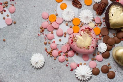 Assorted pink, orange, brown and green chocolate hearts with meringues, pecan Stock Photos