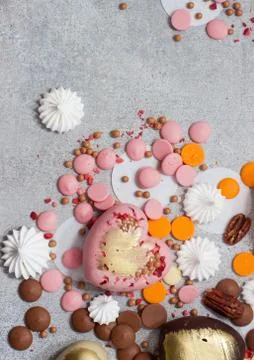 Assorted pink, orange, brown and green chocolate hearts with meringues, pecan Stock Photos