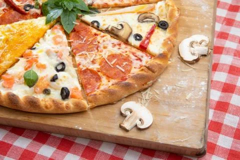 Assorted pizza slices on the Board on checkered tablecloth Stock Photos