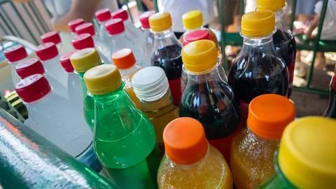 Assorted plastic bottles holding various refreshing sugary drinks with colorful Stock Photos
