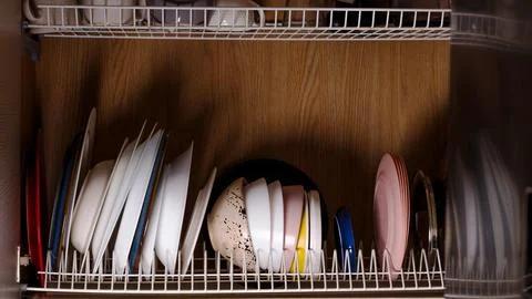 Assorted plates organized on kitchen shelf in indoor setting Stock Photos