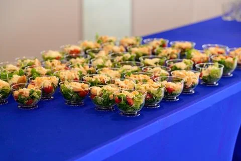 Assorted portions of caesar salad in small plastic cups served during a cat.. Stock Photos