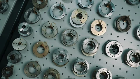 Assorted precision metal circular components and machining fixtures neatly Видео 335860828