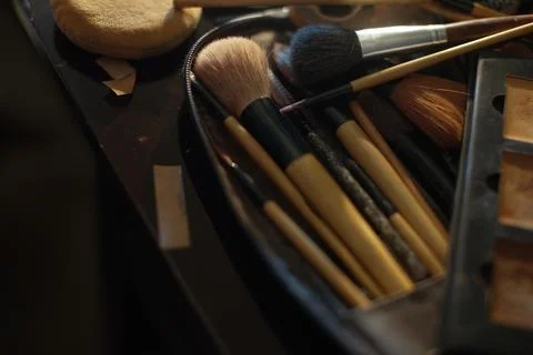 Assorted professional makeup brushes and cosmetic tools stored in a metal c.. Stock Photos