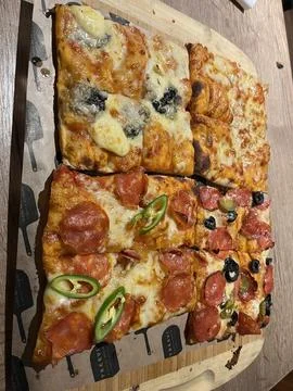 Assorted Rectangular Pizza Slices on Wooden Board Stock Photos