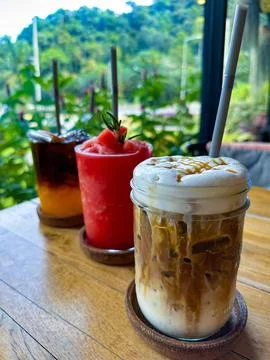 Assorted Refreshing Drinks on a Wooden Table with Tropical Background Stock Photos