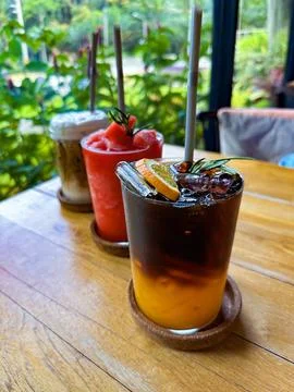 Assorted Refreshing Drinks on a Wooden Table with Tropical Background Stock Photos