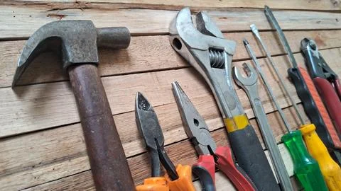Assorted rusty metal hand tools arranged on rustic wooden boards Stock Photos