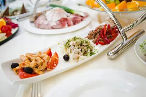 Assorted salads on a white platter at a buffet table Stock Photos