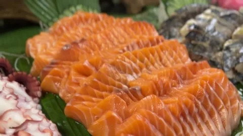 Assorted sashimi with salmon, crab, and octopus on banana leaves Stock Footage 314707995