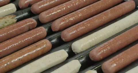 Assorted sausages are fried on a roller grill Stock Footage 264760064