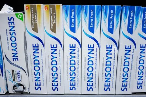 Assorted Sensodyne toothpaste boxes displayed neatly on a retail store shelf Stock Photos