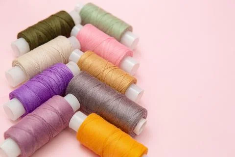 Assorted Sewing Thread Spools On Pink Background Foto stock
