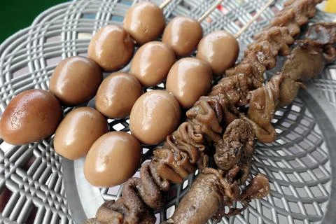 Assorted Skewered Meat and Quail Satay on Grilled Tray Displaying Savory Street  Foto stock