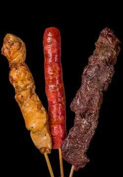 Assorted skewers on black background Stock Photos