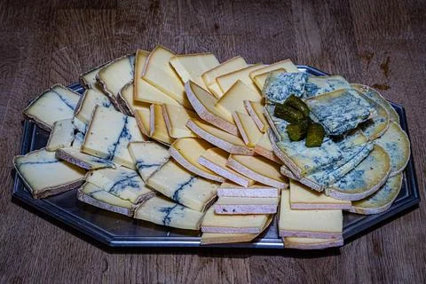 Assorted sliced cheeses including blue cheese arranged on a platter Stock Photos