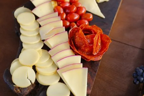 Assorted sliced cheeses on a wooden table Stock Photos