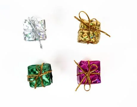 Assorted small gift boxes in silver, green, and red metallic paper. Isolated on Stock Photos