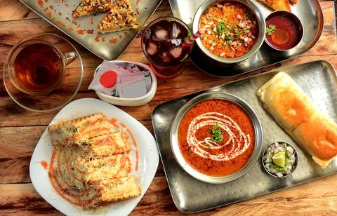 Assorted snack items grilled cheese sandwich,pav bhaji,darjeeling black tea a Stock Photos