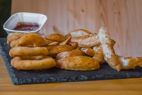 Assorted snacks for beer in the bar. Meat, cheese, onion rings on the grill a 스톡 사진