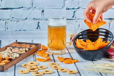 Assorted snacks, chips, and beer on blue table. Table for group of friends Stock Photos