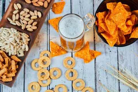 Assorted snacks, chips, and beer on blue table. Table for group of friends Stock Photos