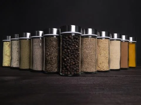 Assorted Spices in Glass Jars on Dark Background Stock Photos