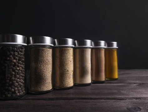 Assorted Spices in Glass Jars on Dark Background Stock Photos