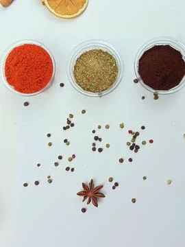 Assorted spices in small containers with peppercorns on white background Stock Photos
