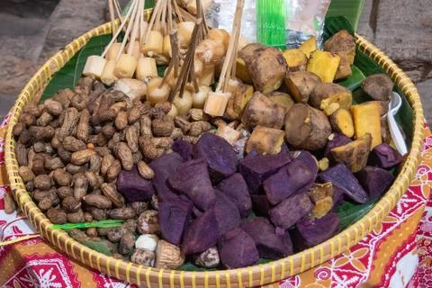 Assorted steamed root vegetables and peanuts in a woven basket Stock Photos