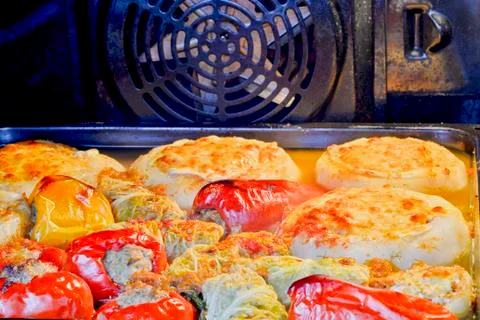 Assorted stuffed peppers, stuffed cabbage and zucchini on a baking sheet in t Stock Photos
