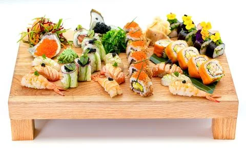 Assorted sushi and nigiri selection on wooden serving board isolated on whi.. Stock Photos