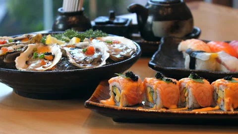 Assorted sushi and seafood dishes on wooden table in Japanese Video stock 292285903