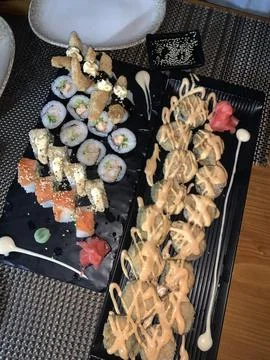 Assorted Sushi Rolls on Black Serving Platter Stock Photos