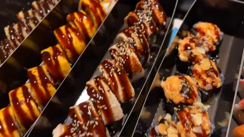 Assorted Sushi Rolls in Black Takeaway Containers with Sauce Stock Footage 334314388