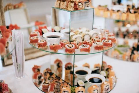 Assorted sushi on trays on table in restaurant. Japanese cuisine Stock Photos