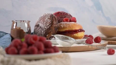 Assorted sweet donuts filled with chocolate and jam garnished with fresh ra.. Stock Photos